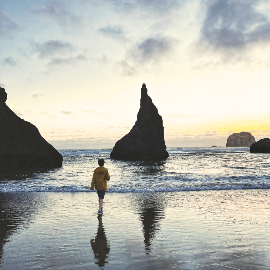 "Face Rock at sunset with young boy walking along the coast"