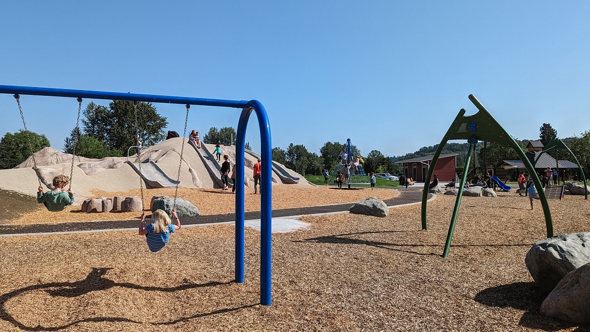 Kids swing on the new swings at Van Doren’s Landing Park’s new playground in Kent