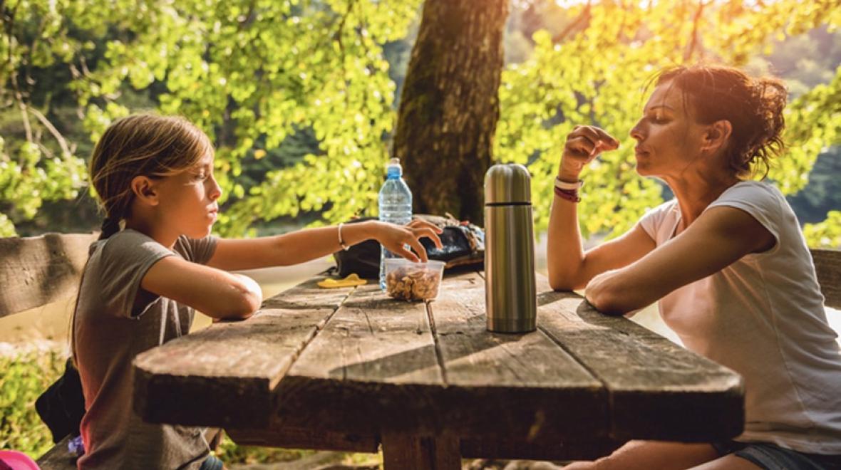 Parent and child eating while camping or hiking