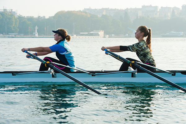 Winter workouts outdoor fitness rowing boat crew women on lake