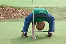 Boy playing mini golf