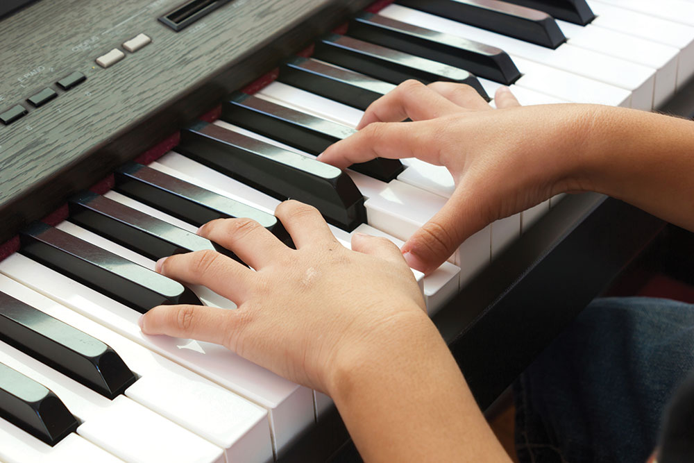 child's fingers on piano