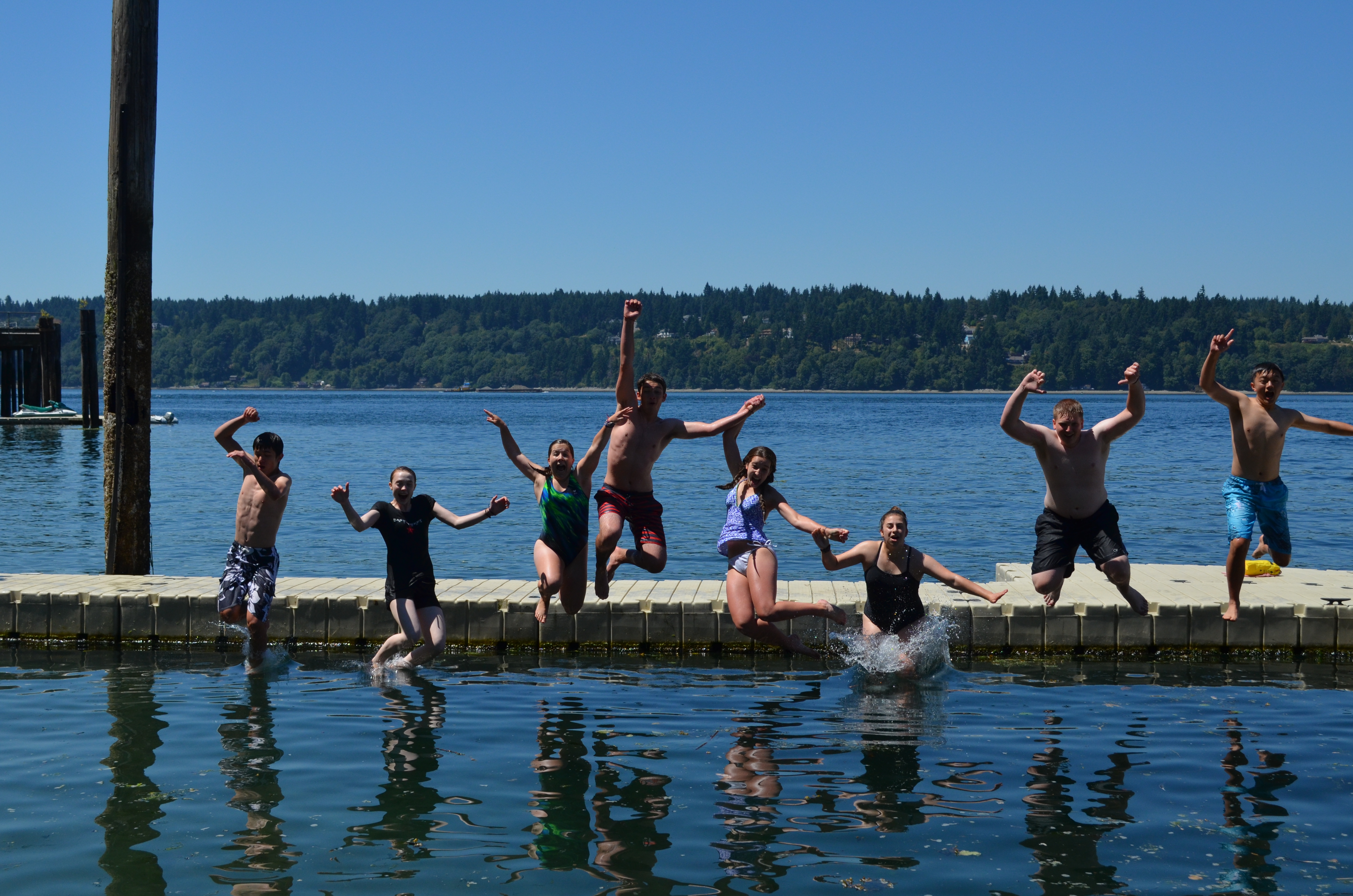 Swimmers jumping off the dock at Camp Sealth