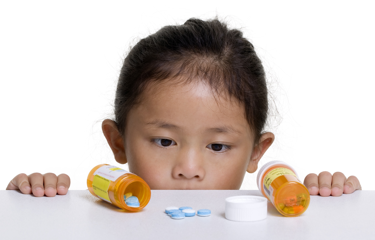 little girl looking at pills