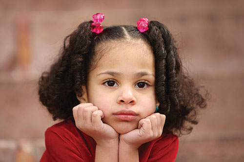 Little girl in time out thinking about consequences looking bored forlorn