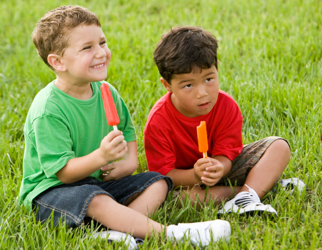 Boys eating popsicles at camp