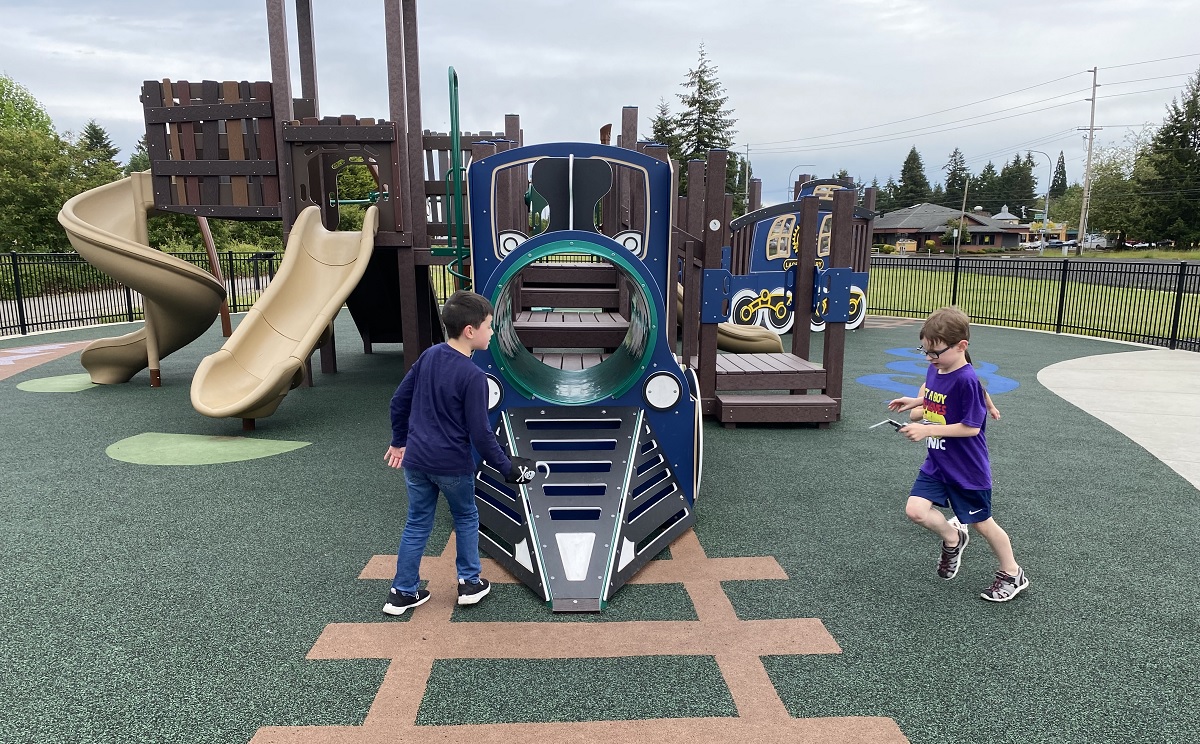 Kids play on the train themed playground at the new Lacey Depot District play area