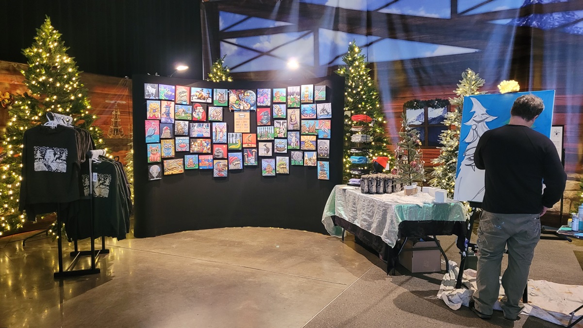 Seattle mural artist Henry paints live at the Seattle Christmas Market on select dates and has paintings for sale