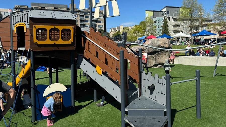 A young girl looks at the treasure box under the playground’s ship at Ballard Commons Park.