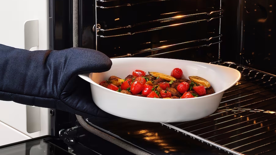 White serving dish being put into the oven is a hosting essential from ikea