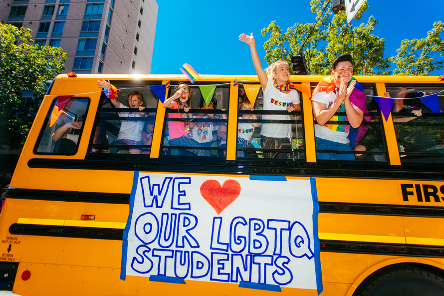 People wave from a bus during the Pride parade in Seattle, one of the city's most famous Seattle Pride events
