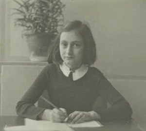Anne Frank writing at a desk