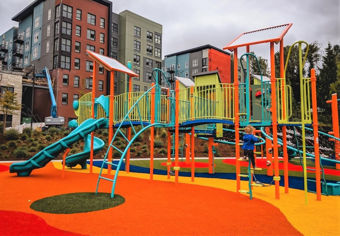 New colorful playground at Totem Lake Park main play structure kids playing blue slides