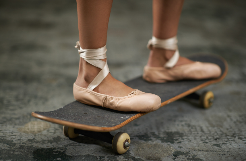 Girl with ballet slippers riding a skateboard