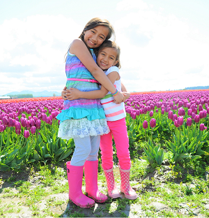 girls in tulip field hugging