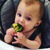 Sweet baby girl eating broccoli