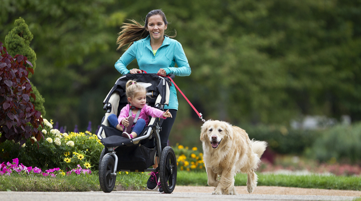 Mom running with child in stroller and dog