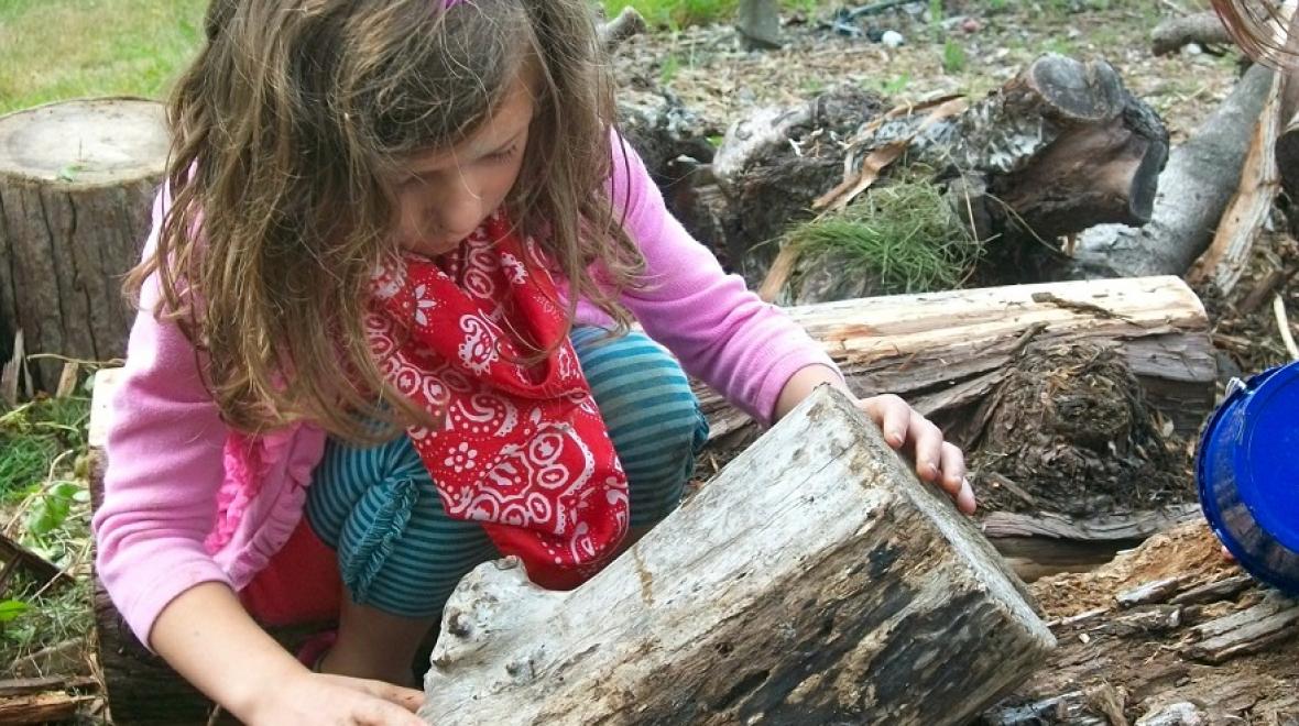 A girl plays with the wood pile at Magnuson Park Children’s Garden in Seattle, among magical forts, treehouses and other spots for kids