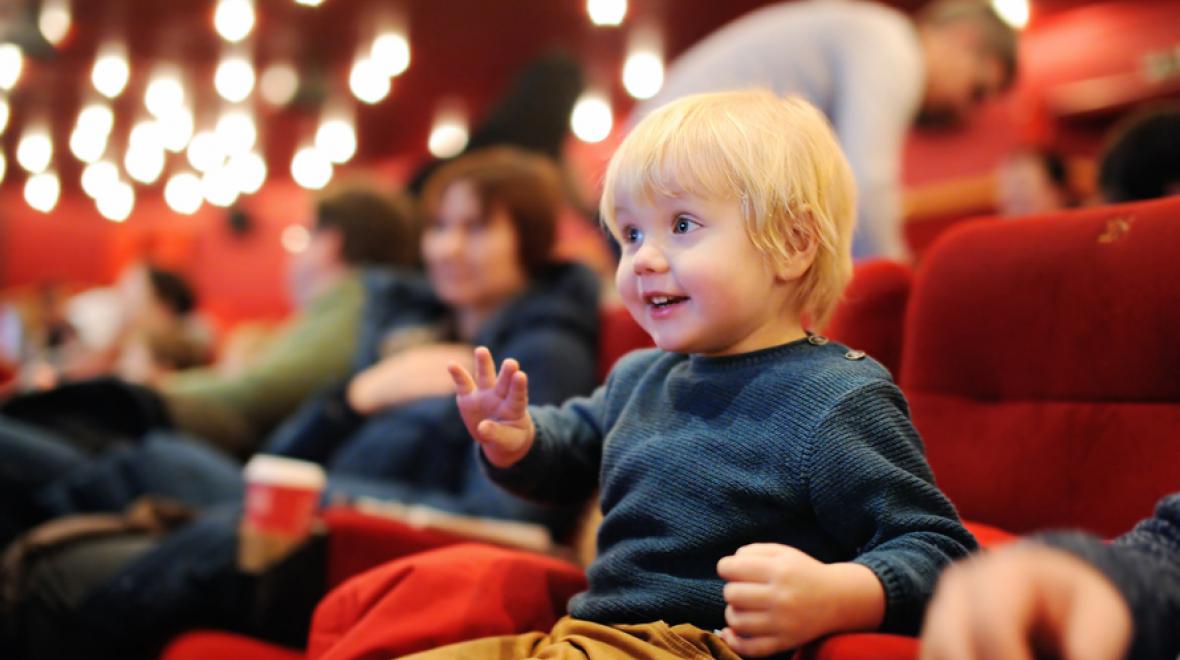 little boy at the theater enjoying a performance
