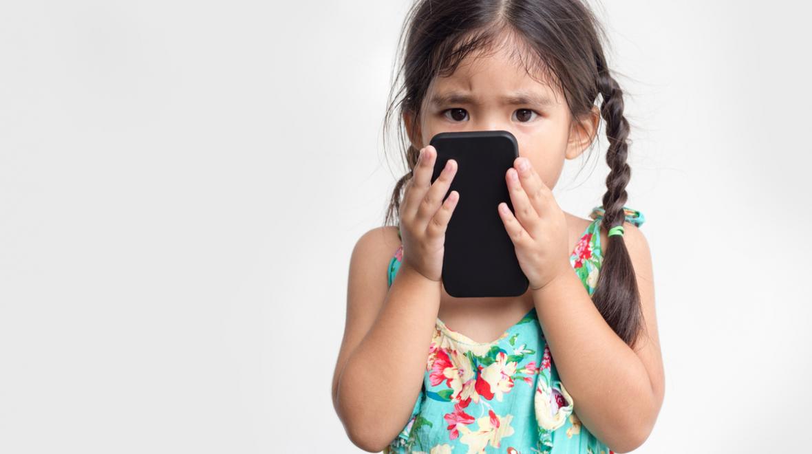 Young girl holding a phone close to her face