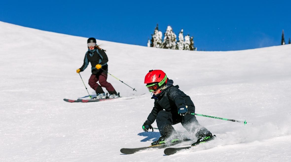 Child and parent skiing at SilverStar Mountain Resort, B.C., Canada