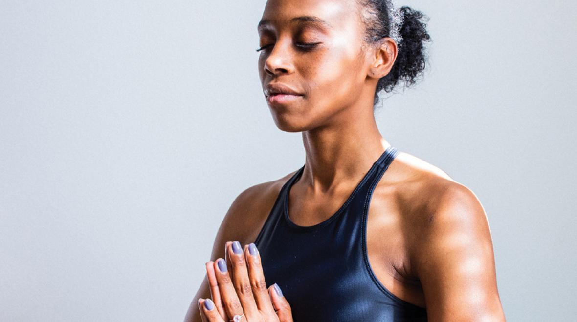 woman meditating with hands together and eyes closed