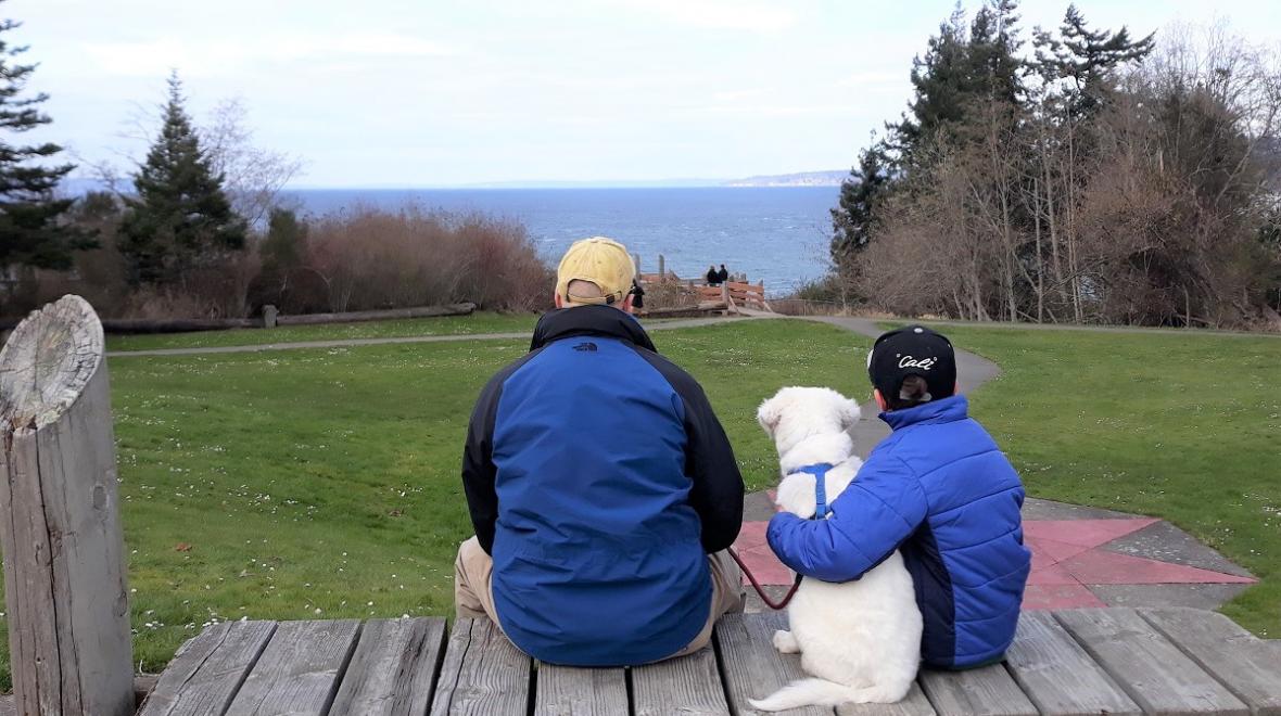 Family-with-dog-looking-at-Puget-Sound-seattle-from-Discovery-Park-daybreak-star-center