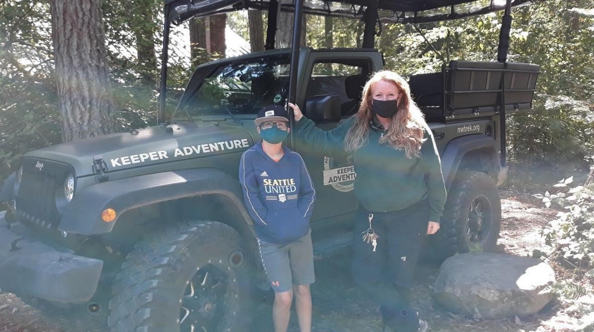 Northwest Trek keeper and tour guide Deanna with the visitor in front of the keeper tour jeep