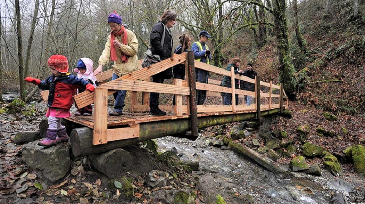 Families on bridge over Swan Creek in Tacoma best fall hikes with kids south puget sound