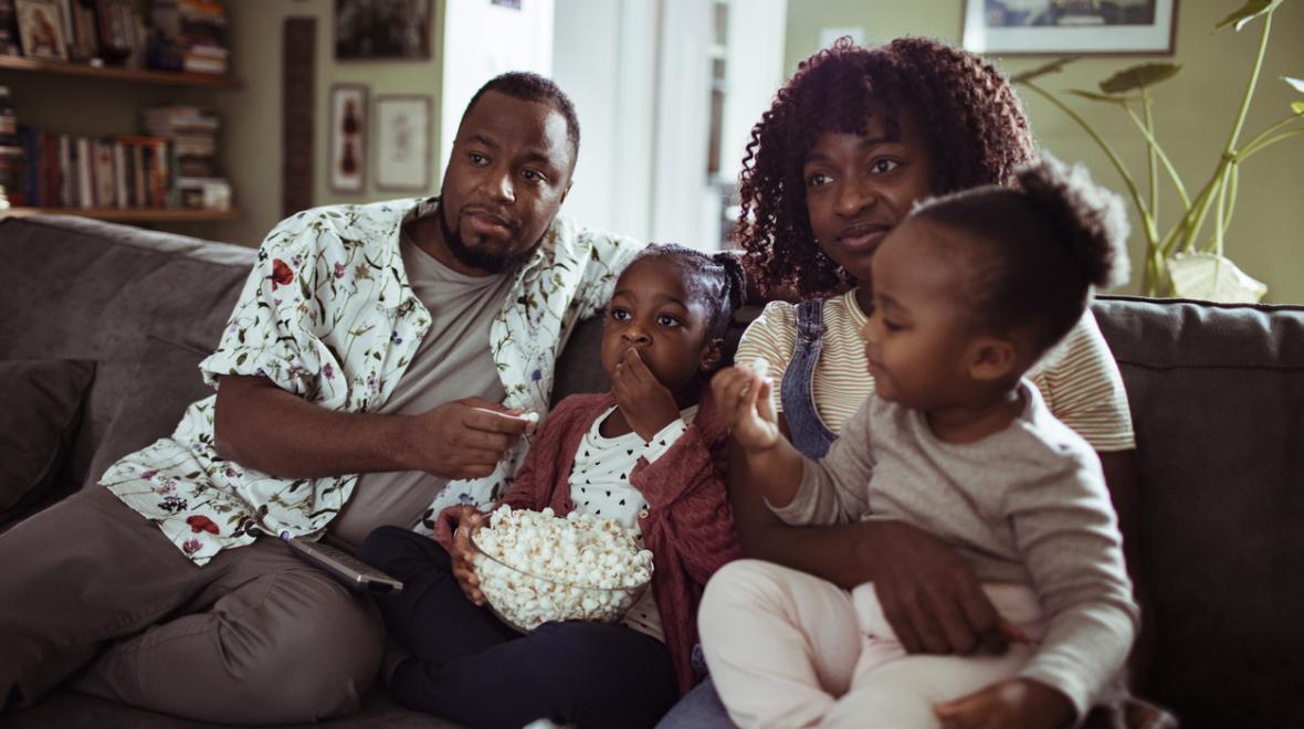 family of four sitting on the couch with popcorn