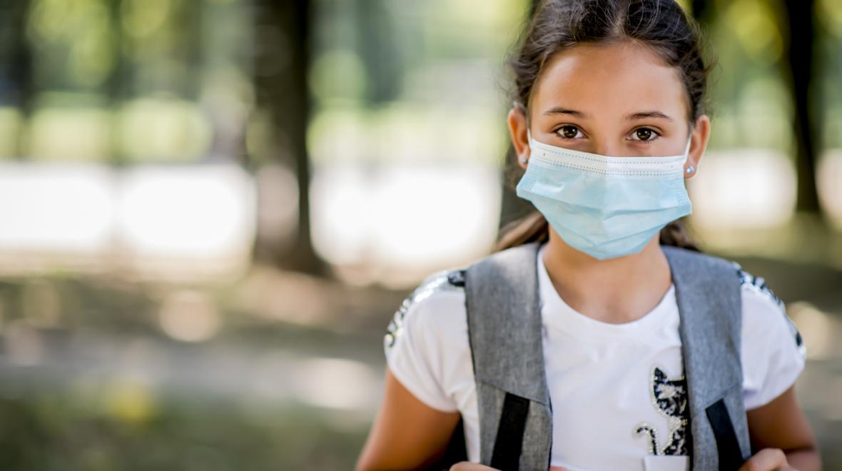 worried girl wearing a backpack and mask