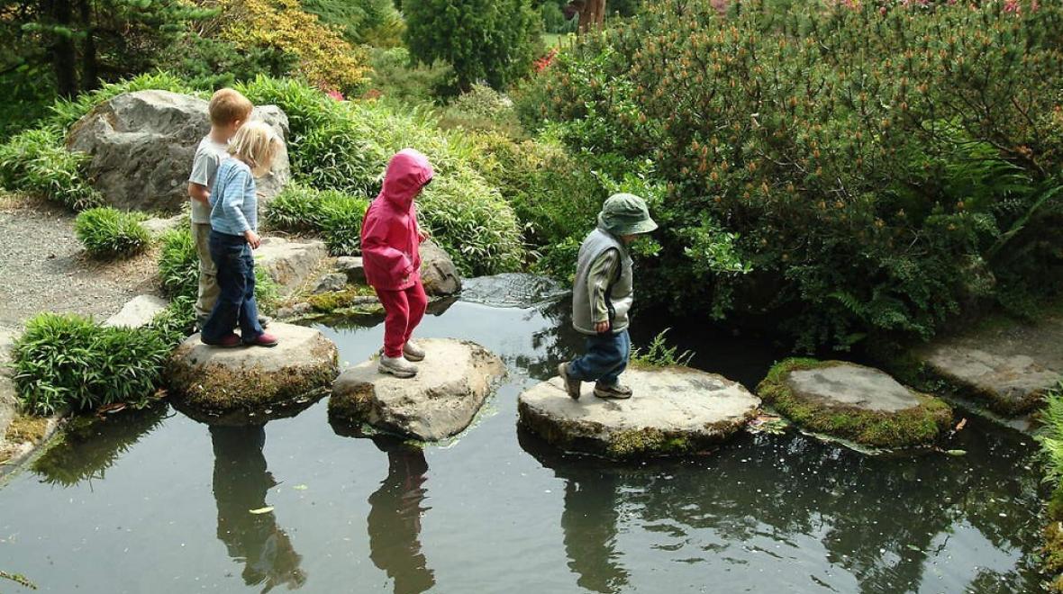 kids on a stone path in a pond in kubota garden