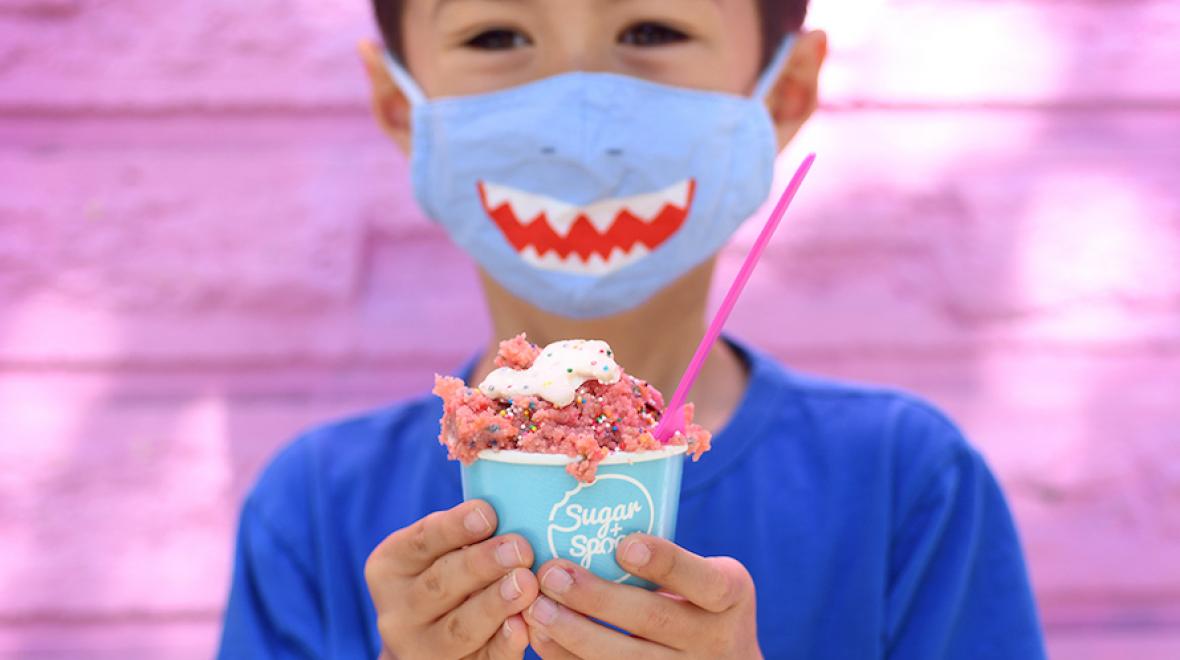 boy in a shark mask holding a cup of edible cookie dough from Sugar + Spoon