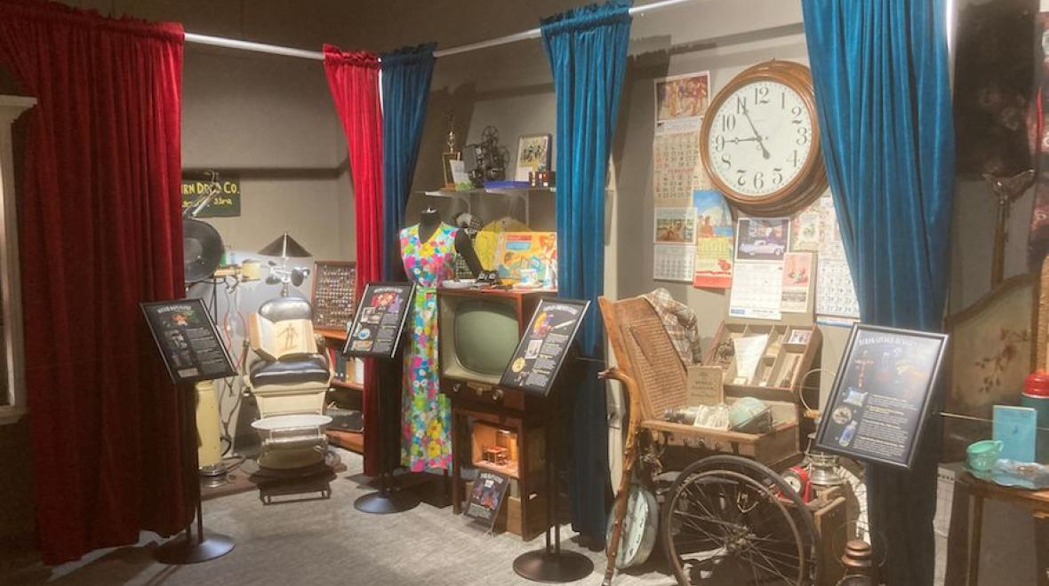 wide snapshot of the closets of curiosity exhibit with red and blue curtains framing the displays