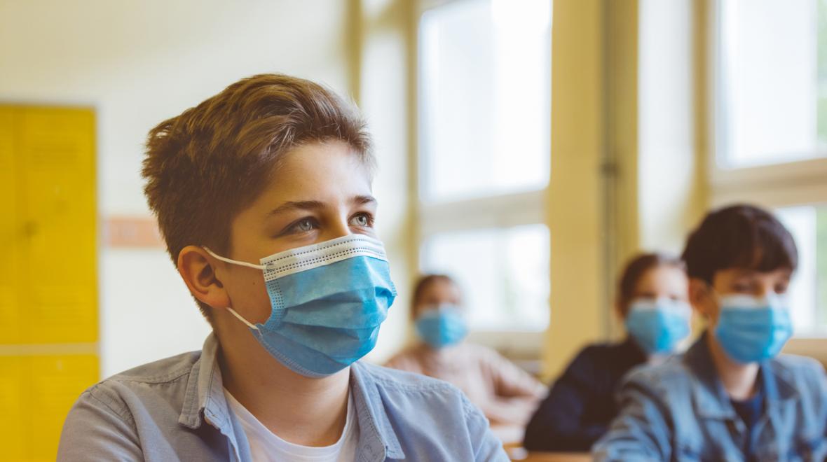 High school students wearing N95 face masks sit in a classroom
