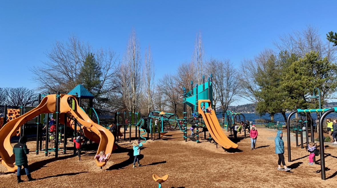 Wide view of new playground at Gene Coulon Memorial Beach Park with girl running in foreground