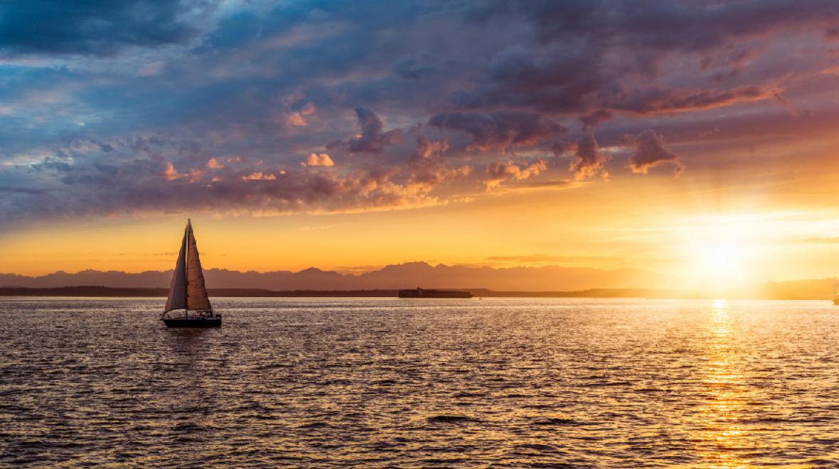 a boat sails at sunset on Elliott Bay is a great seattle date night idea
