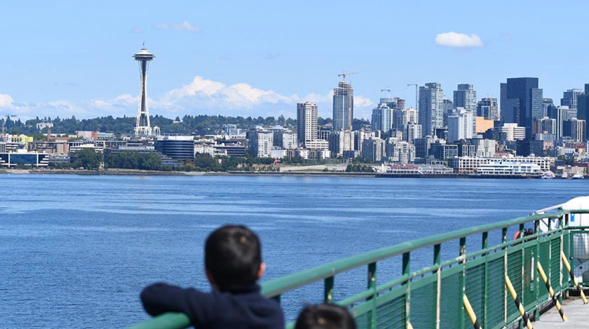 Boys look back at the Seattle skyline on the ferry to Bainbridge Island among best fall activities in Seattle