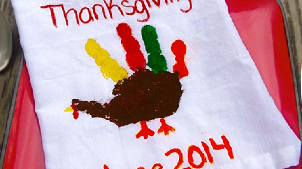 napkin with a child's handprint painted to look like a turkey