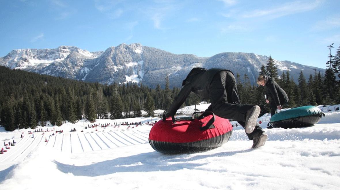 a kid jumps onto a red tube at Snoqualmie tubing hill a best place to tube near Seattle
