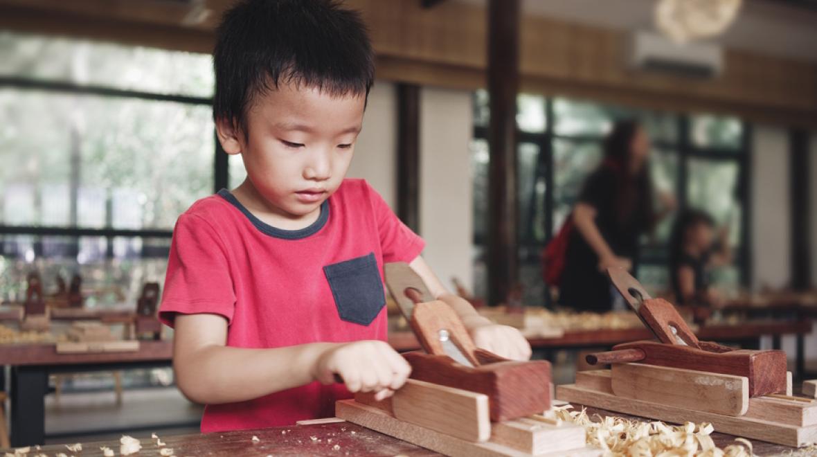 Young boy doing a woodworking project at a camp for creative kids