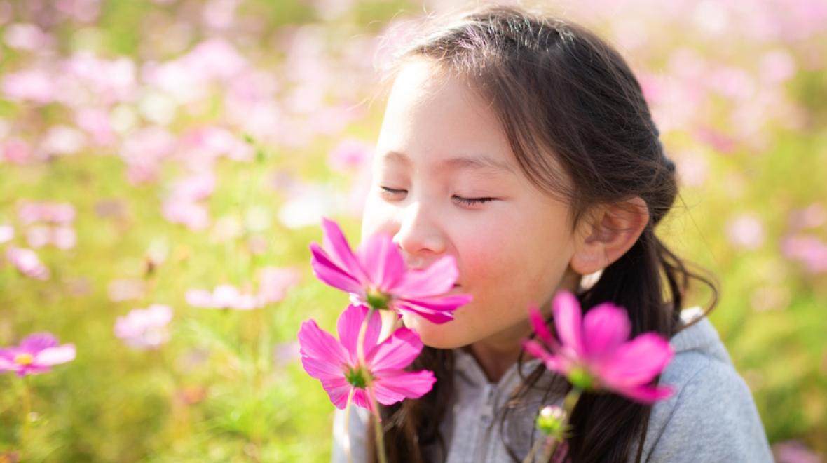 girl smelling a spring flower