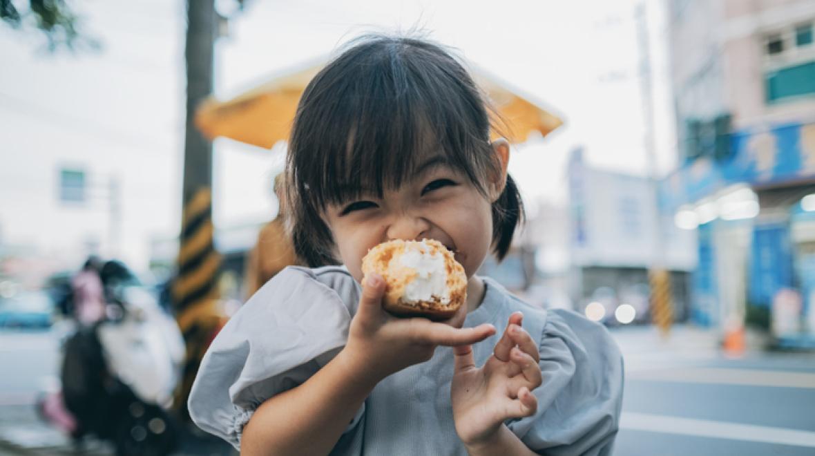 Little girl is very happy to eat cream puffs
