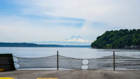 View of Mount Rainier in the distance from viewpoint of standing on the edge of the Washington state ferry car deck family day trip to wonderful Vashon Island