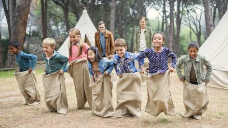 kids in a sack race at a summer camp