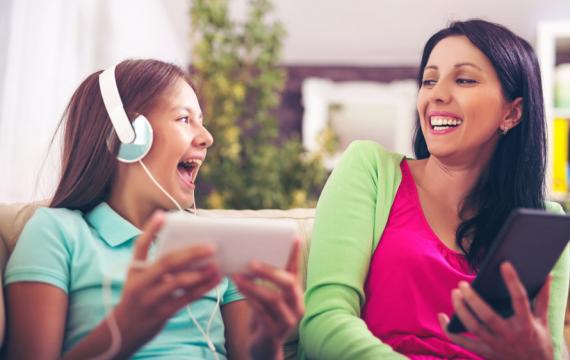 mother and teen daughter listening to a podcast