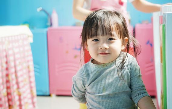 toddler girl looking at the camera with colorful background