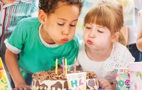 One boy and one girl blowing out birthday candles