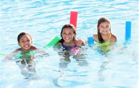 girls swimming with pool noodles