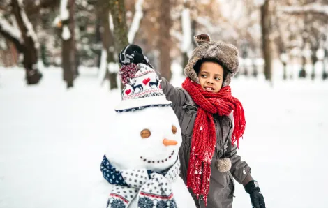 Young girl enjoying the winter by making a snowman